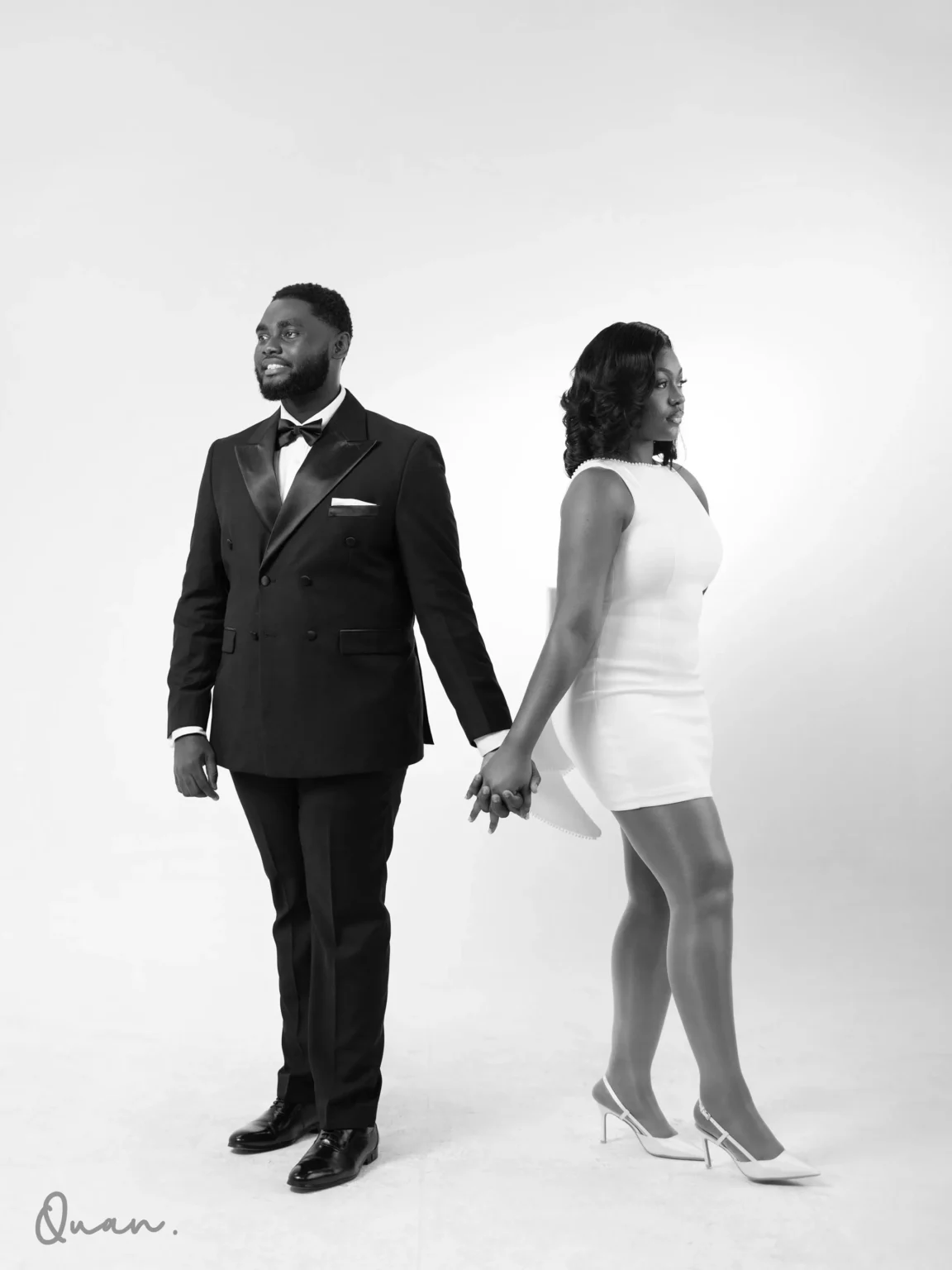 Kwaku and Tess holding hands, in black and white