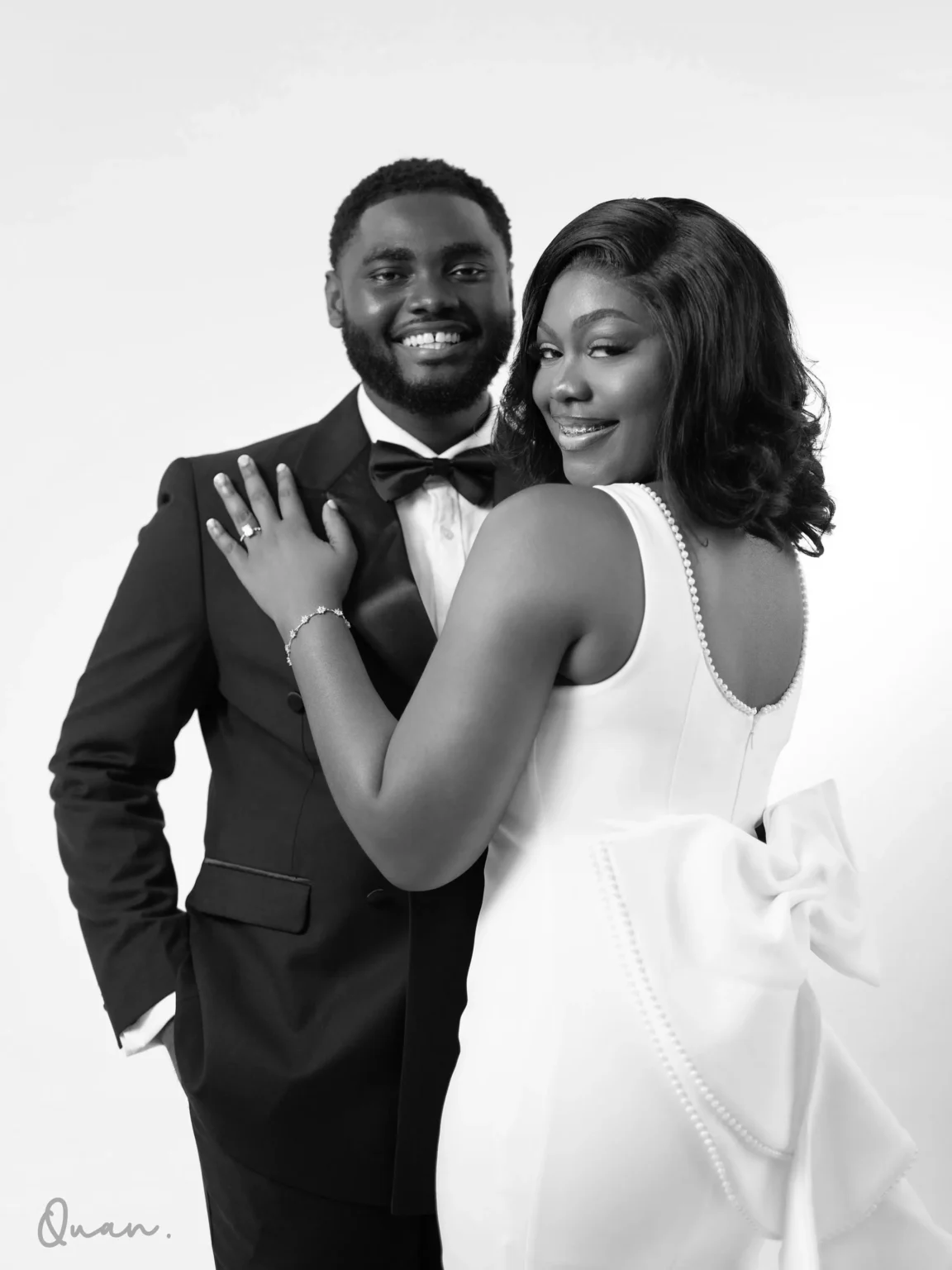 Tess with her hand on Kwaku's shoulder, showing her ring
